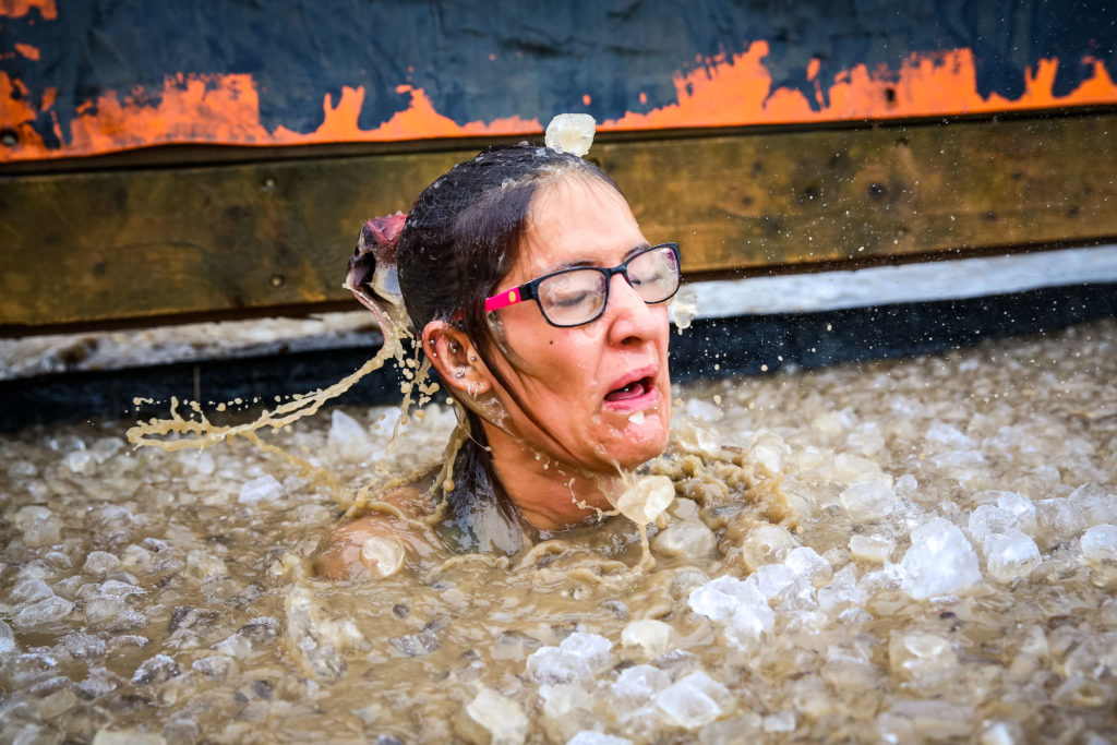 A woman bursts out of ice water.