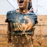 Participant smiling while mud waters splashing on her