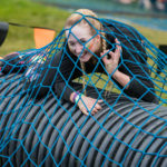A woman winking from beneath a blue net