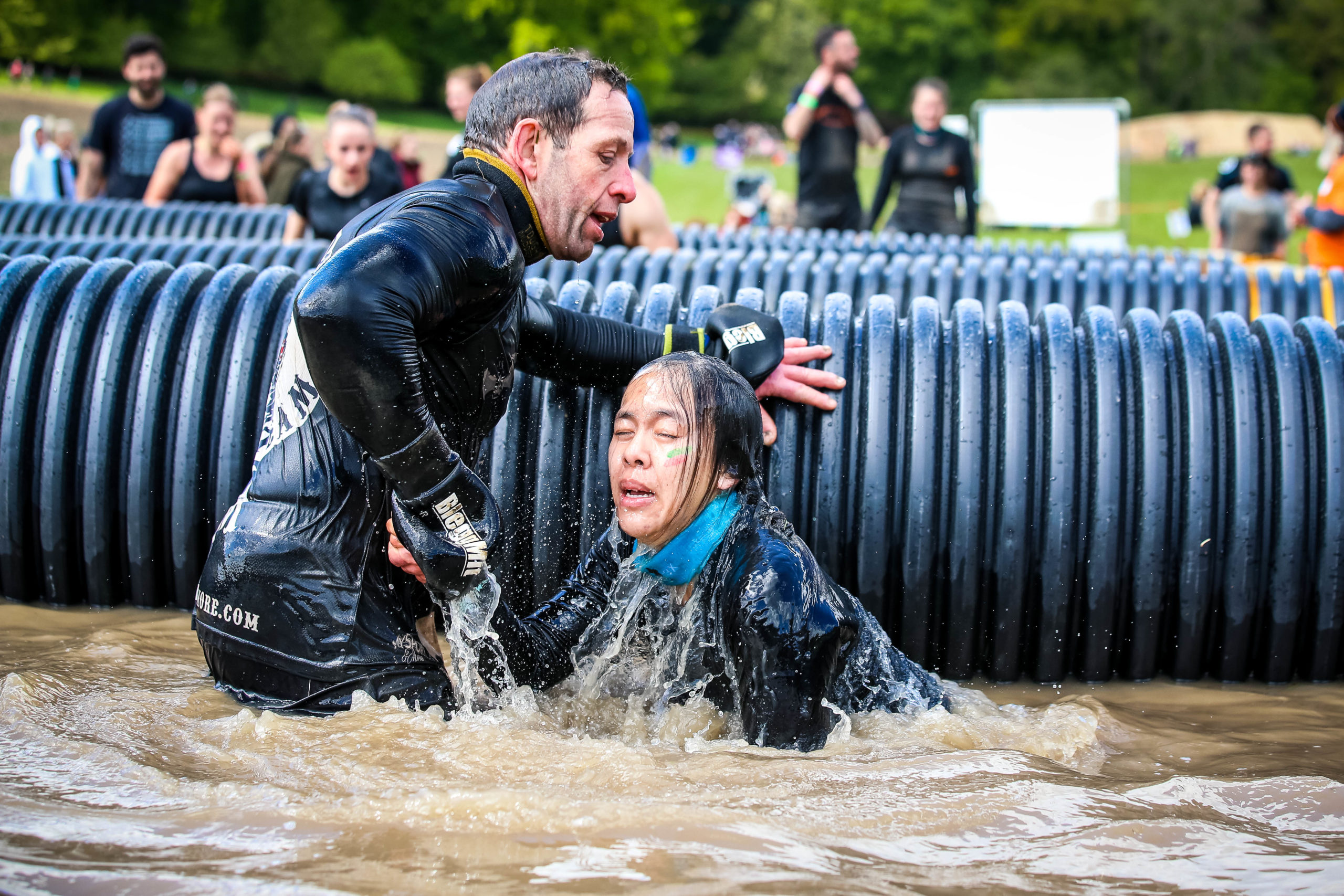 Man helping friend over obstacle