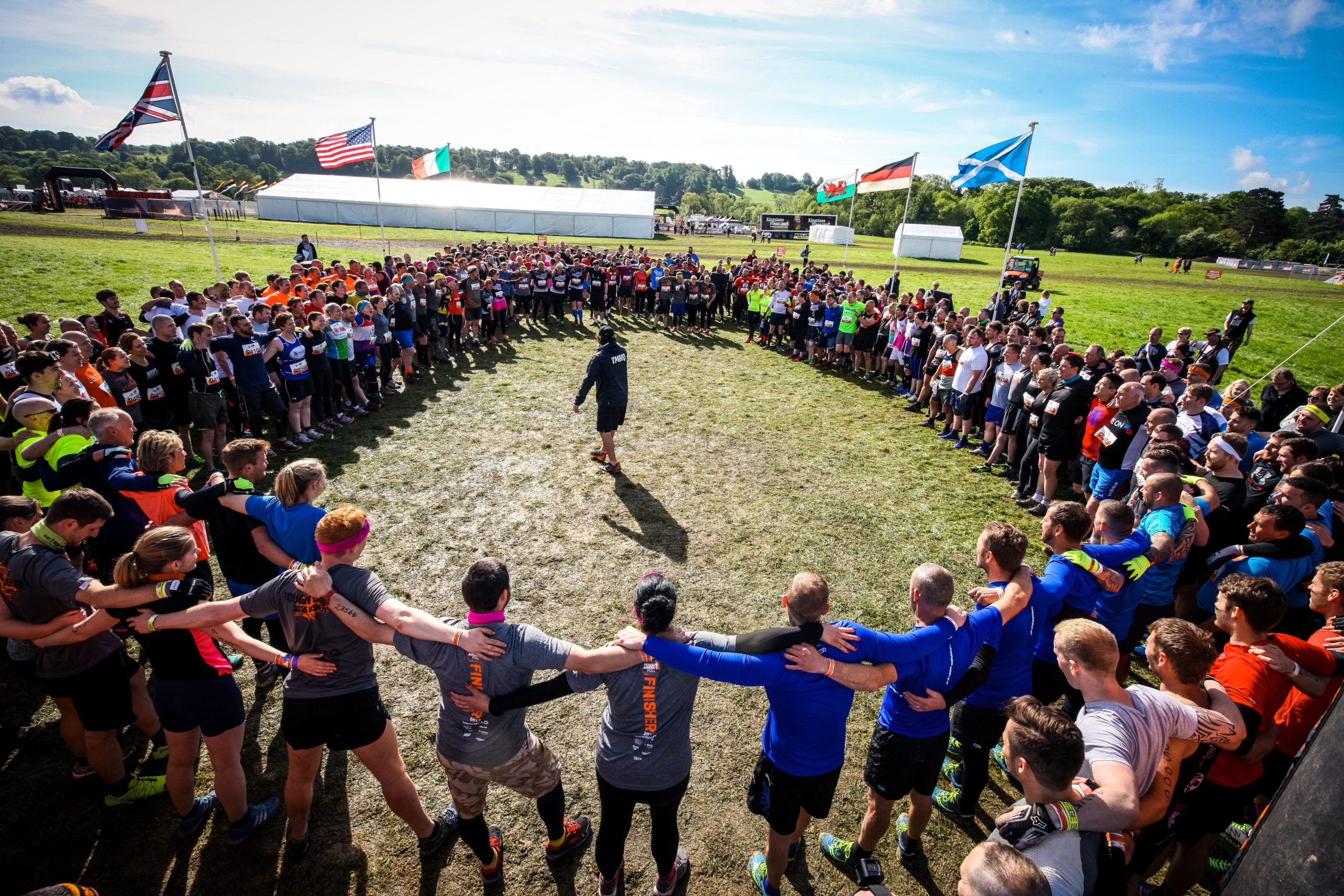 A large group of people stand in a circle