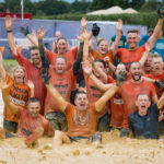 Team in red t-shirts in mud
