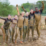 Participants posing for picture with their bodies covered by mud