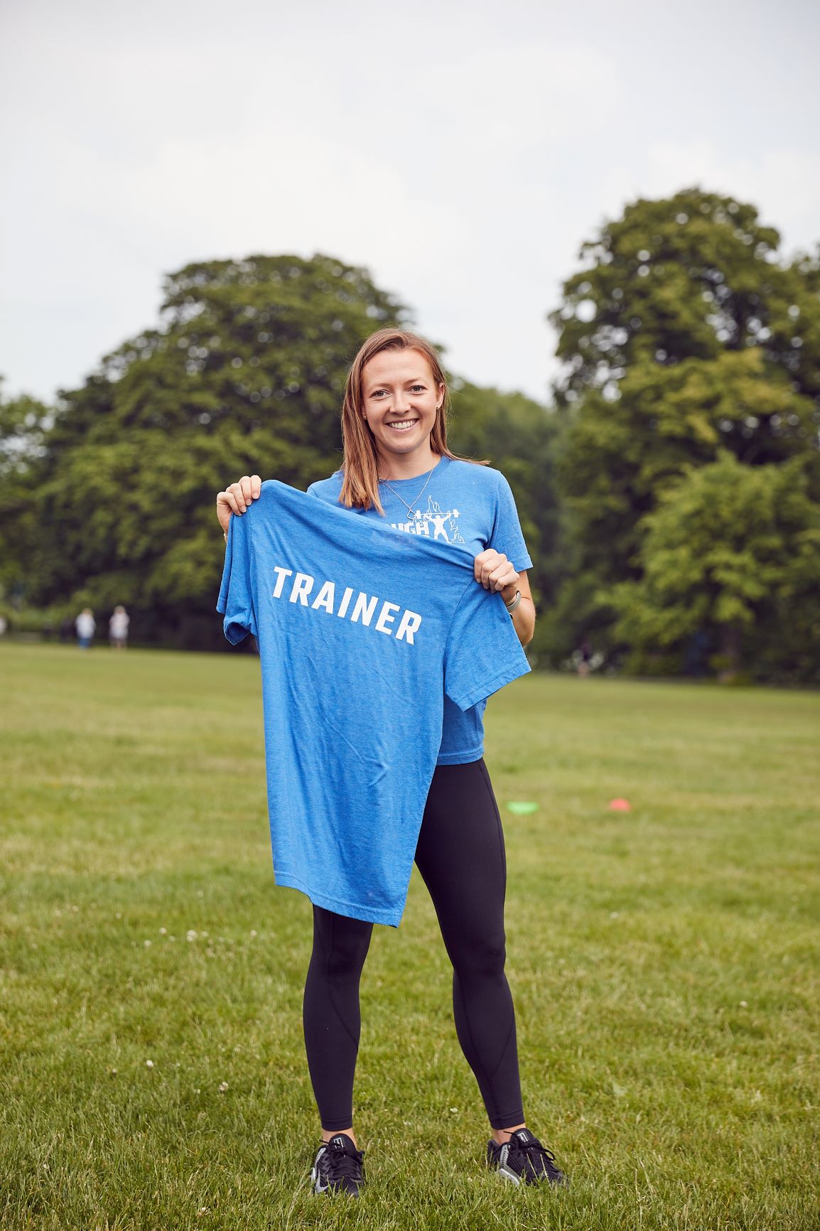 Woman showing off her Trainer Shirt