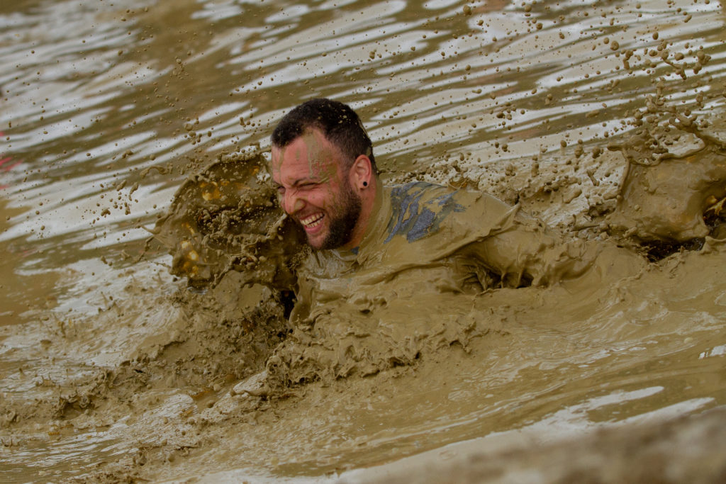 man chest deep in mud run obstacles