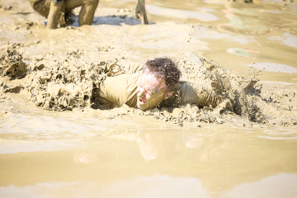 man in mud water obstacle Tough Mudder