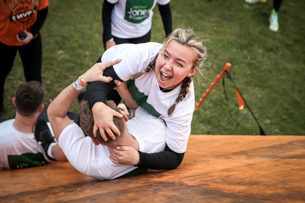 friends helping each other on Tough Mudder obstacle