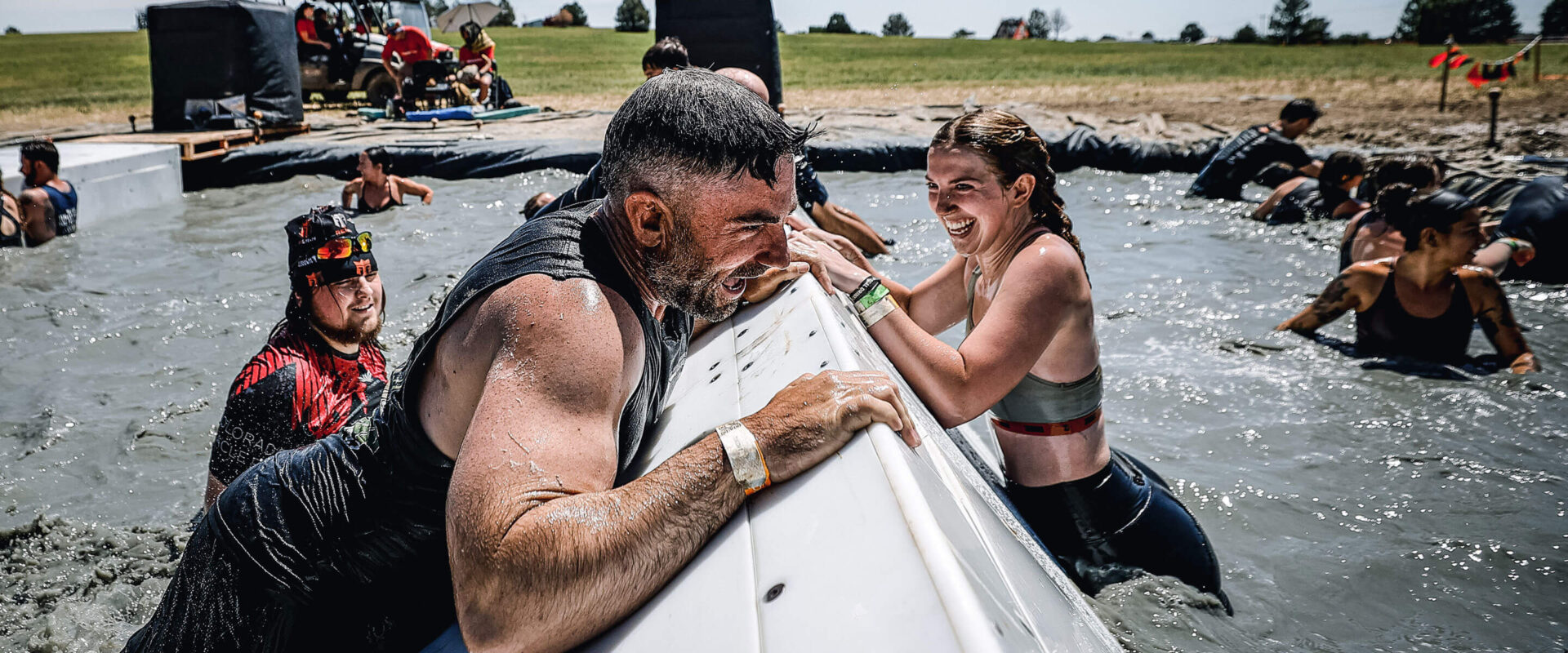 Mudder smiling while helping each other on a ramp