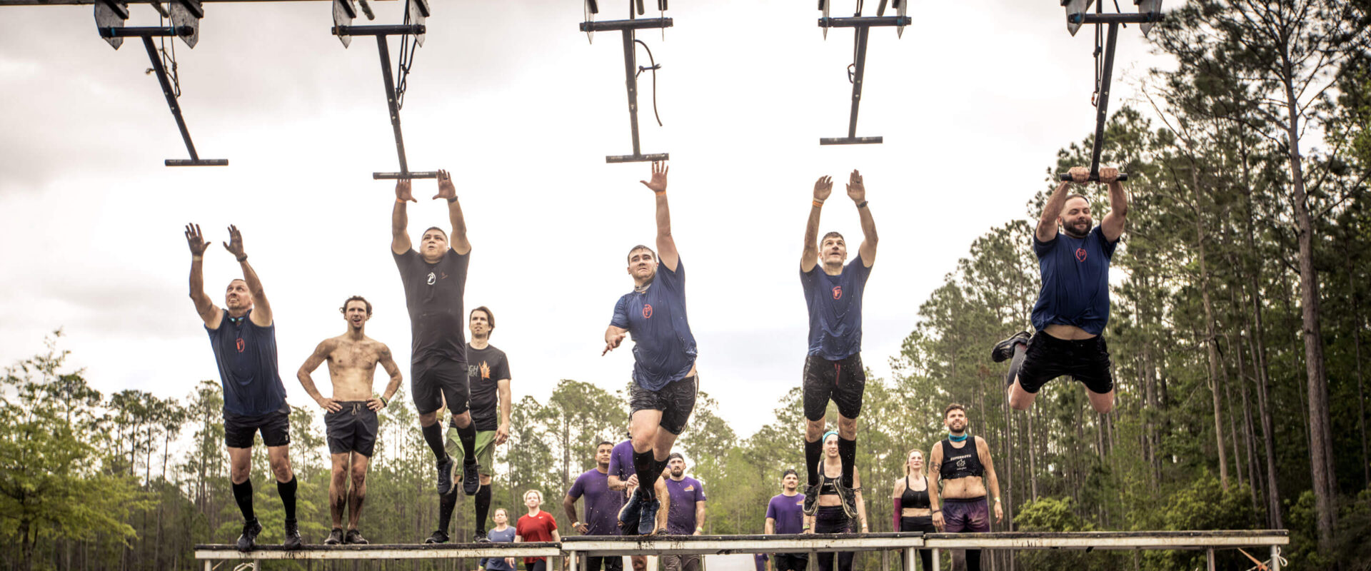 A team jumping at the same time to hold on a bar